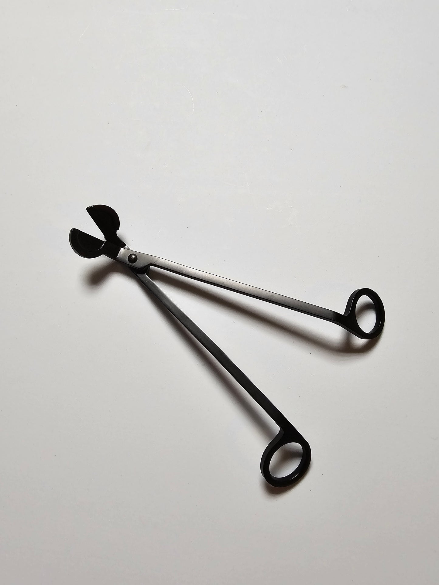 Black Candle trimmer on a light gray background