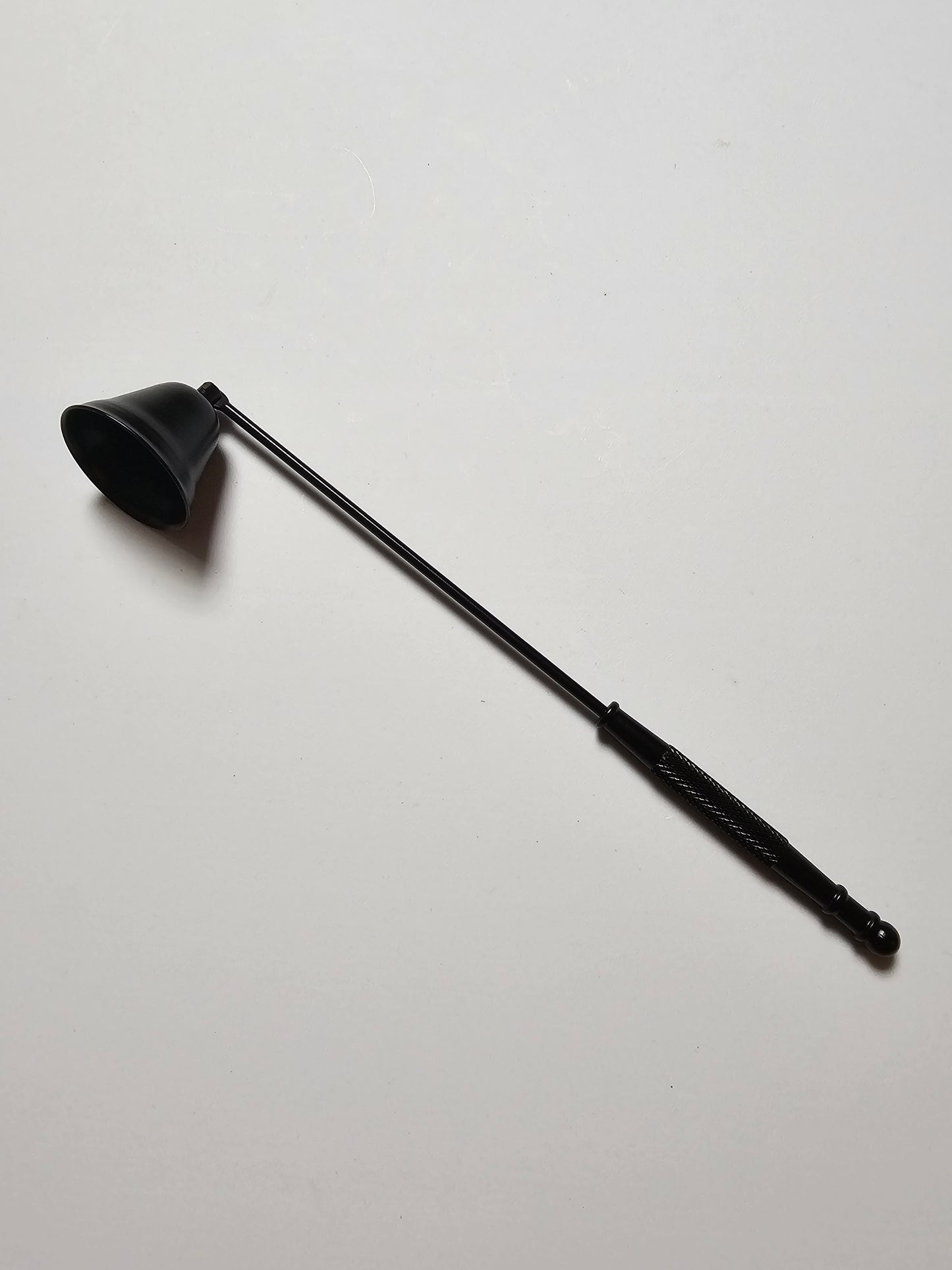 Black candle snuffer on a white background