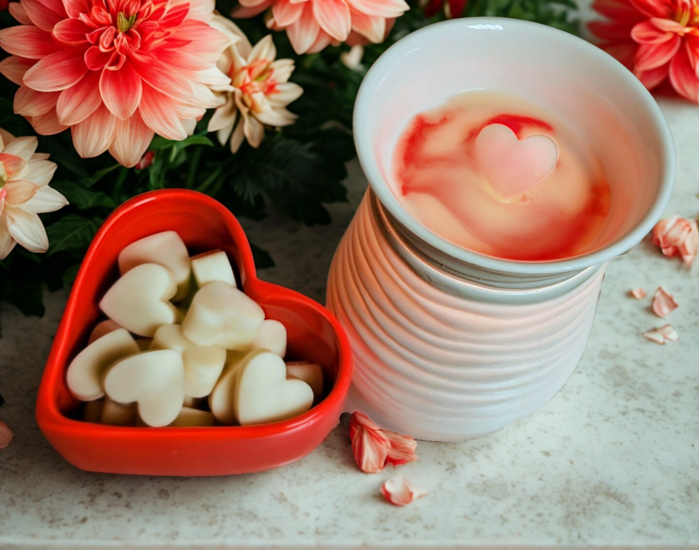 Heart-shaped container with heart-shaped wax melts next to a white wax Melter with one of the hearts melted.