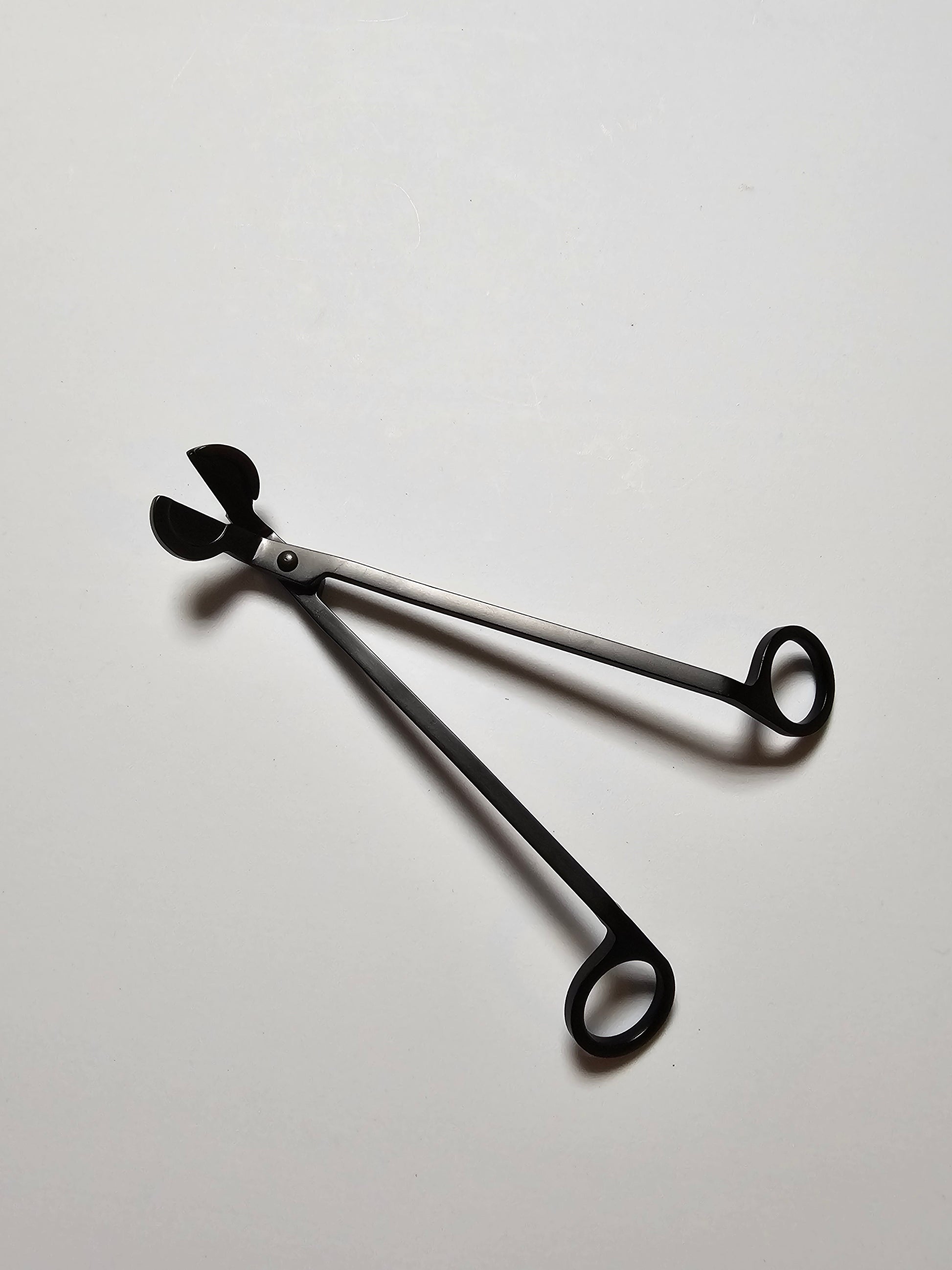 Black Candle trimmer on a light gray background
